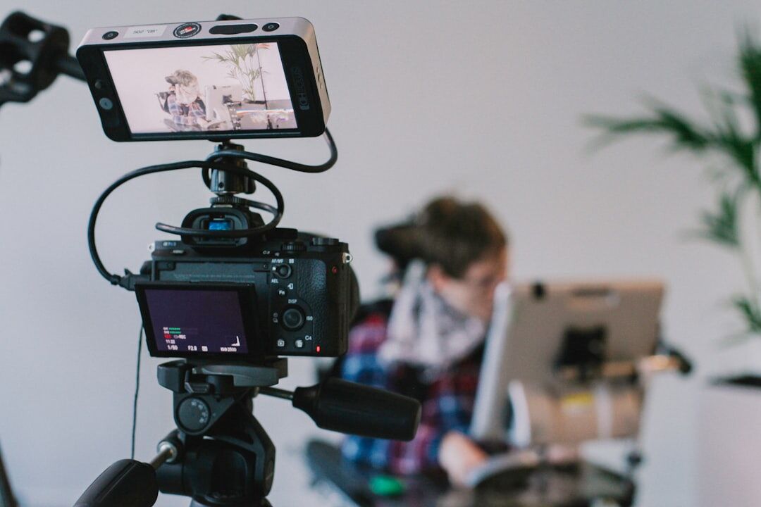 Belgian technician operating live video broadcast equipment on a tripod
